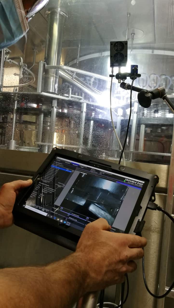 A maintenance operator setting up the TroublePad high-speed camera on a high-speed bottling line.